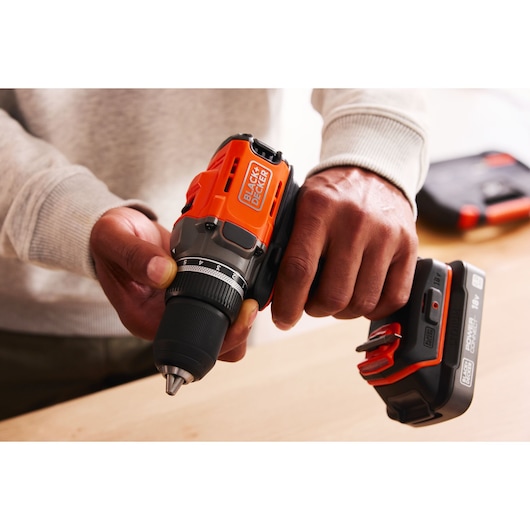 Photo of BLACKDECKER cordless drill BCD382D1 held in hand, showing orange and black design.