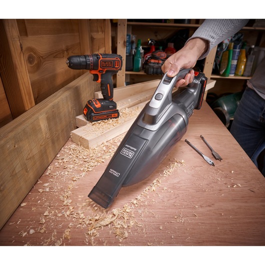 BLACKDECKER BCHV001C1 handheld vacuum cleaning wood shavings in workshop, cordless drill visible in background