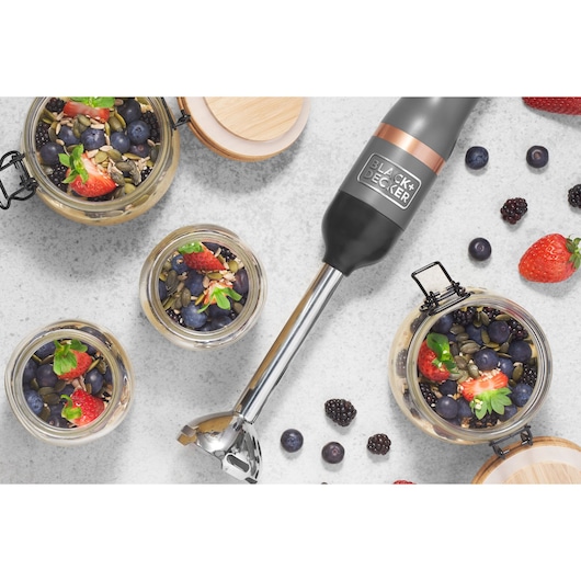 BLACK+DECKER BCKM1016KSG hand blender with stainless steel shaft on white surface beside jars of berries and seeds.