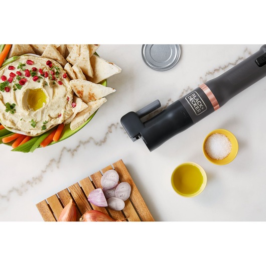 BLACK+DECKER BCKM1011KGF electric can opener on kitchen counter with food ingredients, top-down view.