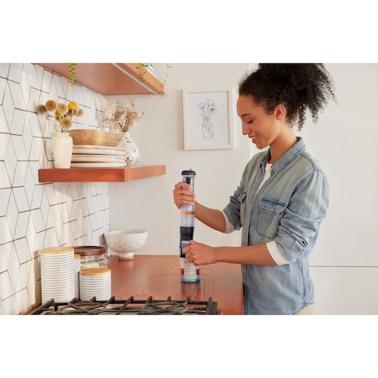 BLACKDECKER BCKM1012KG handheld mixer in use on kitchen counter, modern decor in background.