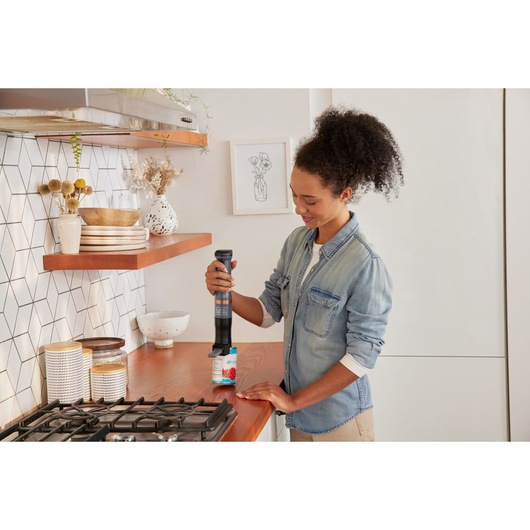 BLACKDECKER BCKM1012KG cordless multi-tool used in a kitchen setting on a wooden countertop.