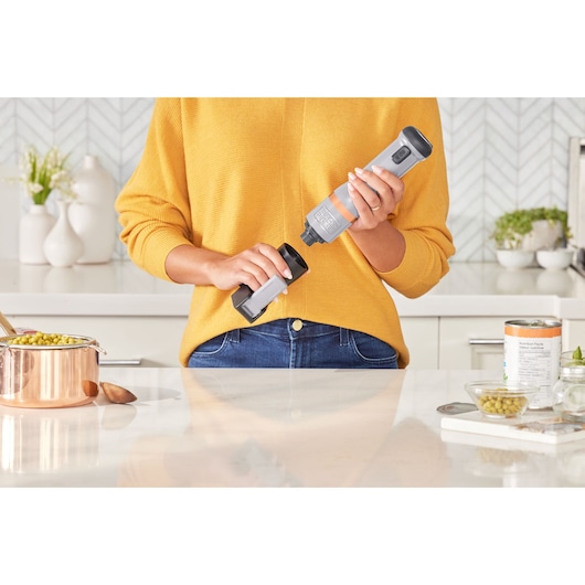 Photo of BLACKDECKER BCKM1012KG electric can opener held by person in kitchen near canned food.