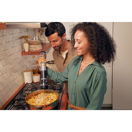 BLACKDECKER BCKM1012KG hand blender in use blending pasta in a pan on kitchen stove.
