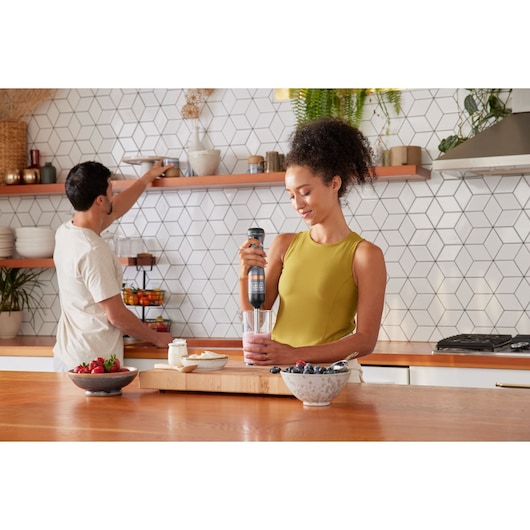 BLACKDECKER BCKM1012KG hand blender used to mix smoothie in a glass in a modern kitchen setting.