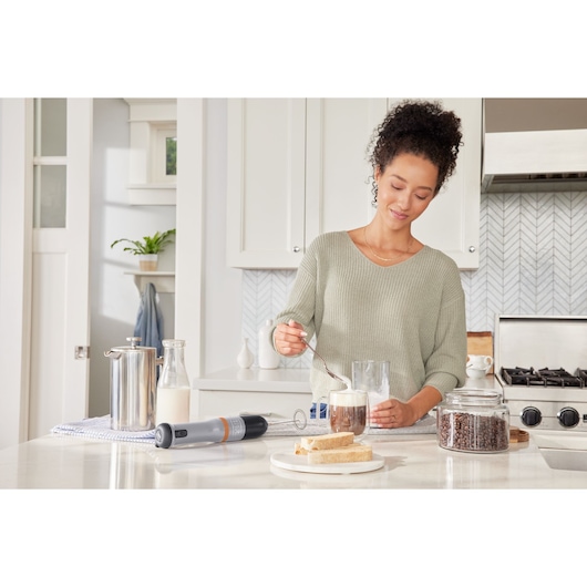 Photo of BLACKDECKER BCKM1012KG handheld milk frother on a kitchen counter with coffee, bread, and coffee beans.