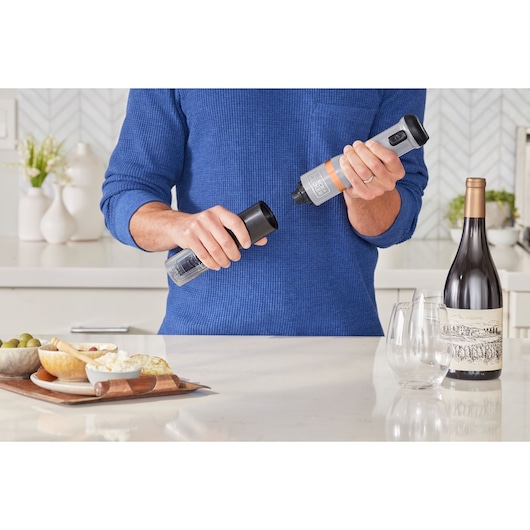Photo of BLACKDECKER BCKM1016KSG electric wine opener being used in a modern kitchen with wine and snacks.