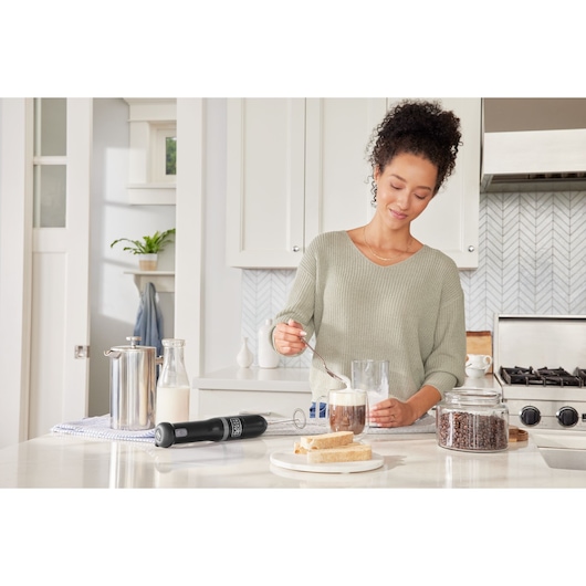 Photo of BLACK+DECKER BCKM101MFFF milk frother on a kitchen counter with coffee, bread, and a jar of coffee beans.