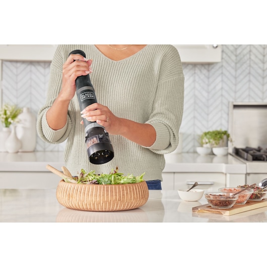 Photo of BLACKDECKER electric pepper mill BCKM101SPFF in use over a salad bowl in a modern kitchen.