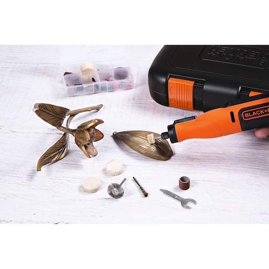 BLACK+DECKER BCRT8IK rotary tool with accessories polishing metal leaf sculpture, side angle.
