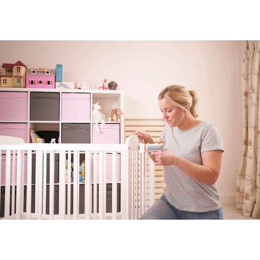 BLACKDECKER BCRTA01 handheld tool used in nursery, white crib and pink storage cubes in background.