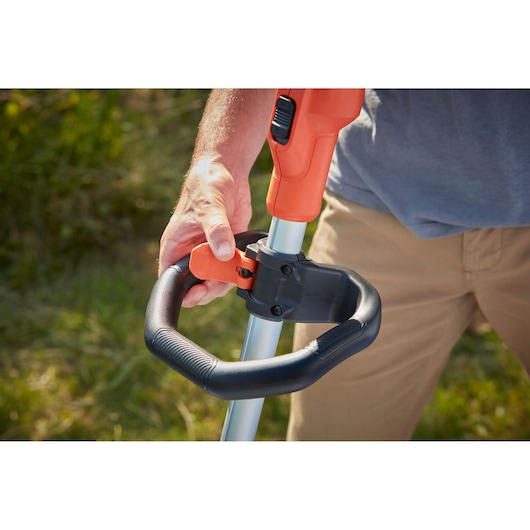 BLACKDECKER BCSTE636L1 grass trimmer close-up showing handle adjustment outdoors.