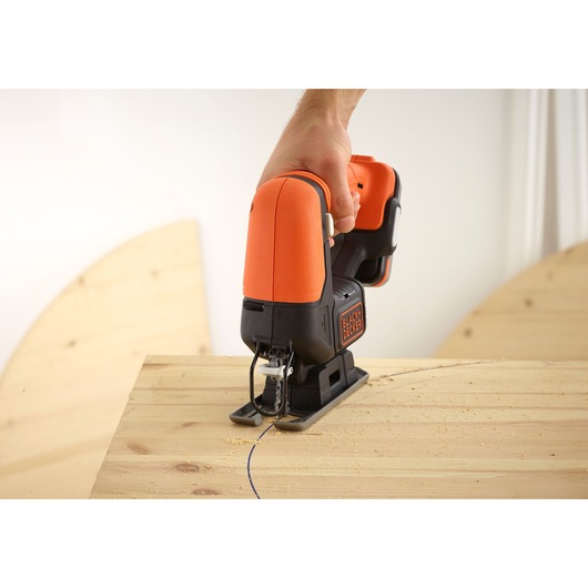 BLACKDECKER BDCJS12N jigsaw in use, cutting curved line into wooden board, close-up photography.