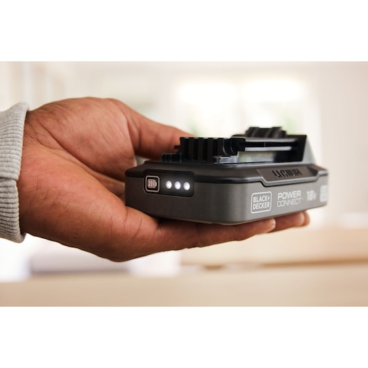Photo of BLACK+DECKER BDL2018S 18V lithium-ion battery with LED charge indicators held in hand.