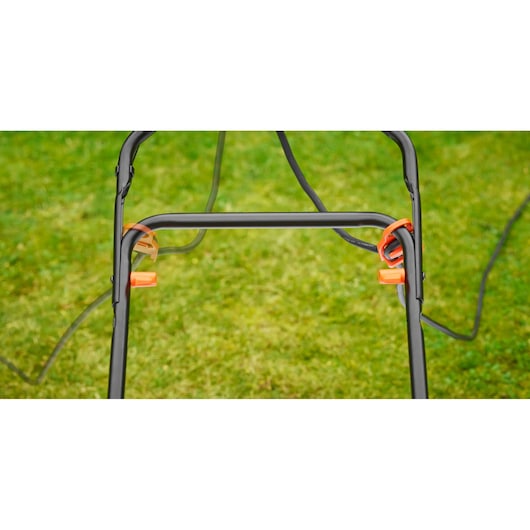 BLACKDECKER BEMW481BGL2 lawn mower handle frame with orange cable holders, outdoor grass background