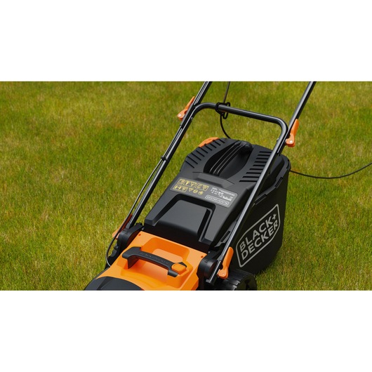 BLACK+DECKER BEMWP400-QS lawn mower with black and orange design on grass, close-up of handle and motor.