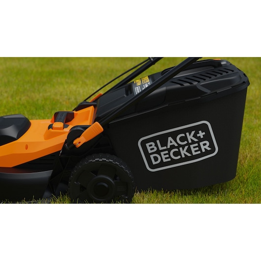 Photo of BLACKDECKER BEMWP400-QS lawn mower side view, black and orange design, on grassy lawn.