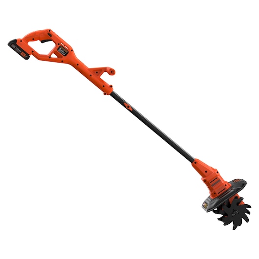 A BLACK+DECKER cordless garden cultivator with an orange and black body, featuring a long handle and rotating blade attachment at the end, designed for soil cultivation.