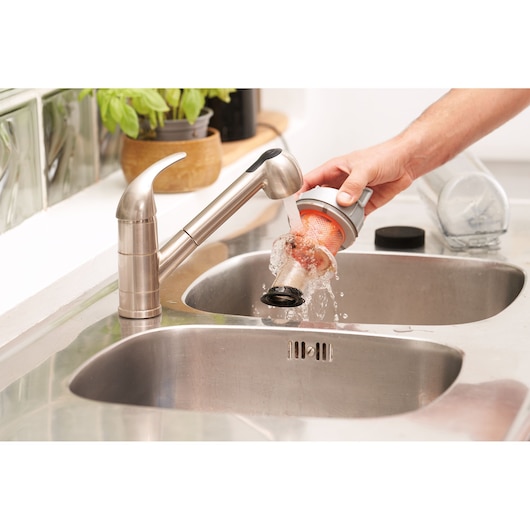 BLACKDECKER BHFEA520J vacuum filter being washed under faucet in kitchen sink, close-up.