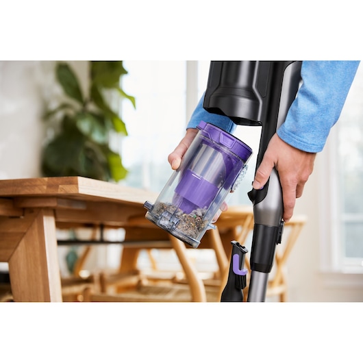 Photo of BLACKDECKER BHFEA640WP vacuum cleaner with visible dust container being emptied in a modern home setting.