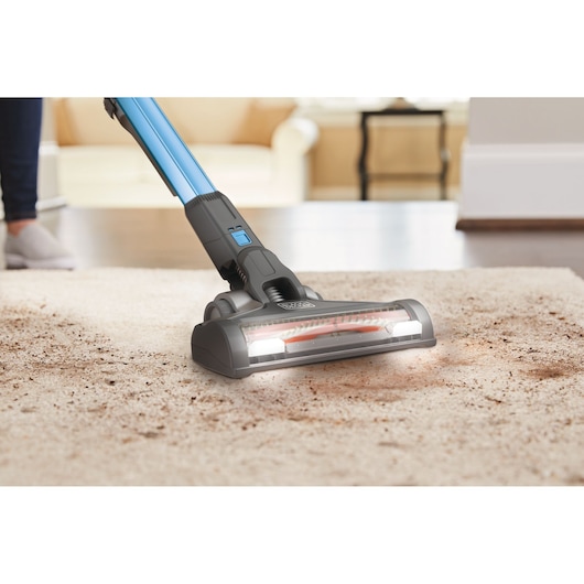 BLACKDECKER BHFEV362D vacuum cleaner cleaning dirt from carpet in a living room, front angle.