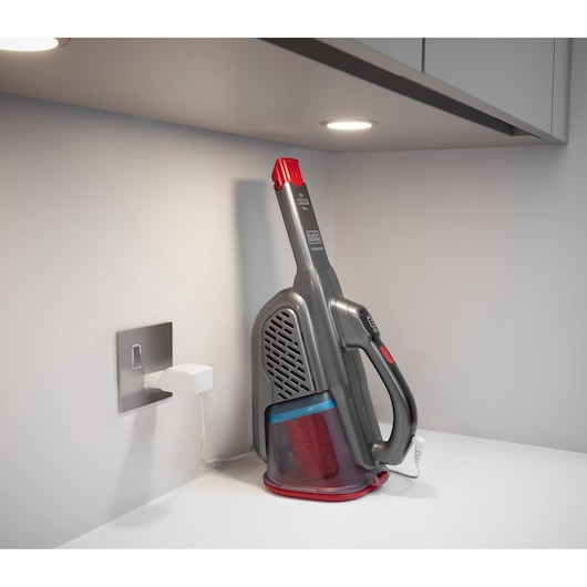 BLACKDECKER BHHV315J handheld vacuum cleaner with charging cable on white countertop.