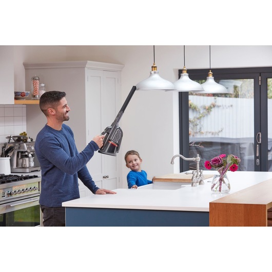 BLACKDECKER handheld vacuum BHHV520JF cleaning kitchen pendant lights with long nozzle attachment.