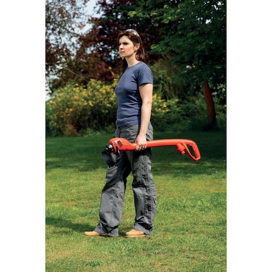 Photo of BLACKDECKER GL250 grass trimmer held by a person outdoors on lawn.