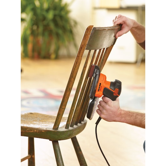 BLACK+DECKER KA2000KA10 detail sander used to sand wooden chair spindles indoors.