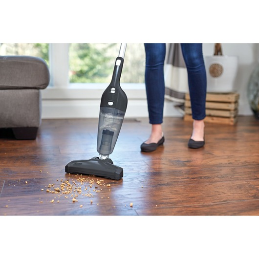 BLACKDECKER NSVA315J stick vacuum cleaning crumbs on hardwood floor in home setting.