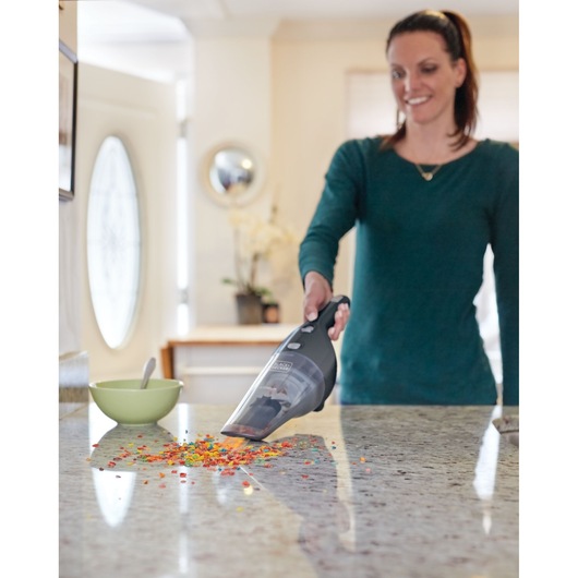 BLACKDECKER NSVA315J hand vacuum cleaning colorful cereal on kitchen countertop.