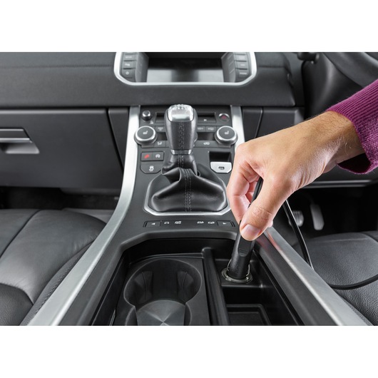 BLACKDECKER NVB12AV car vacuum plugged into vehicle power socket, close-up of center console.