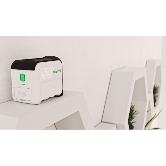 BLACKDECKER REVBDLL100 laser level with black and white casing on a white shelf, side angle.