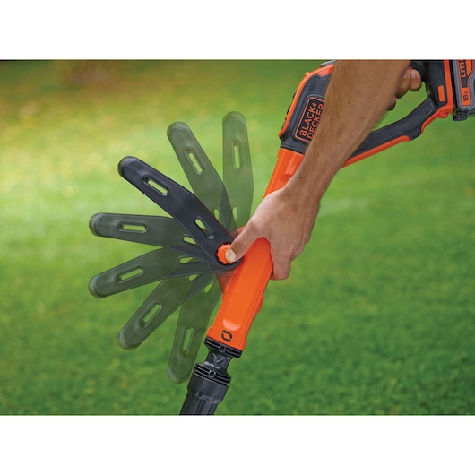Photo of BLACKDECKER STC1840EPC grass trimmer being adjusted, showing rotating head mechanism.