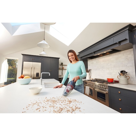 BLACKDECKER SVB520JW handheld vacuum cleaning crumbs on kitchen countertop, lifestyle photography.
