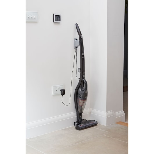 BLACKDECKER SVB620JW cordless stick vacuum cleaner standing upright against white wall, home interior, side view.