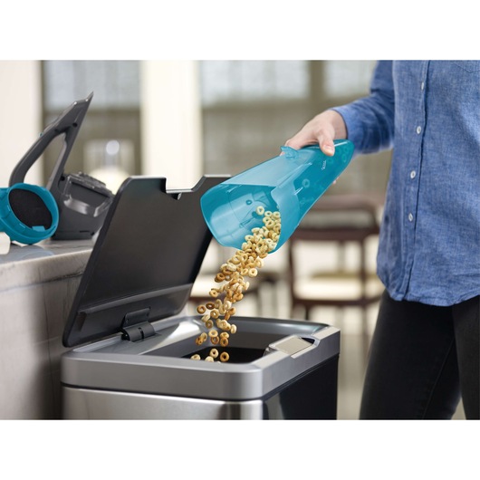 BLACKDECKER WDA320J handheld vacuum dustbin emptied into trash can, close-up indoor.